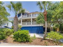 Charming coastal home featuring double balconies, a blue garage, and tropical landscaping at 3009 Palm Blvd, Isle of Palms, SC 29451
