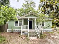 Charming green cottage with inviting front porch and well-maintained landscaping at 307 Mill St, Walterboro, SC 29488