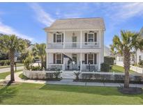Charming two-story white home featuring a double front porch and a neatly landscaped yard with a white picket fence at 3381 Stockdale St, Mount Pleasant, SC 29466