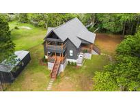 Stunning aerial view of a modern two-story home with wraparound decks and a lush green lawn at 3399 Freeman Hill Rd, Johns Island, SC 29455