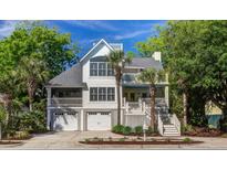 Charming two-story home featuring double garages and palm trees in a desirable location at 413 Station 22 1/2 St, Sullivans Island, SC 29482
