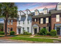 Beautiful townhome exterior featuring brick, white siding, and a well-manicured lawn at 754 Certificate Ct, Charleston, SC 29414