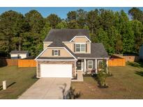 Charming two-story home with stone accents, well-kept lawn, and an attached two car garage at 8035 Mckayla Rd, Summerville, SC 29483