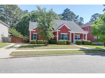 Charming red home with black shutters, manicured landscaping, and inviting front porch at 1126 Rearick Rd, Johns Island, SC 29455