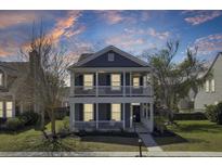 Charming two-story home boasts a double porch, nice landscaping and a beautiful, colorful sunset backdrop at 117 Red Leaf Blvd, Moncks Corner, SC 29461