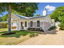 Charming home exterior features a manicured lawn and a welcoming entrance with attractive gravel driveway at 1474 Indian St, Mount Pleasant, SC 29464