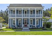Charming two-story blue home featuring a double porch and a manicured lawn at 176 Clearblue Loop, Summerville, SC 29486