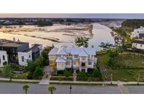 Stunning waterfront home with lush landscaping, elegant architecture, and a serene river view at twilight at 332 Bayley Rd, Daniel Island, SC 29492