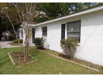 Charming single-story home with white brick exterior and well-maintained lawn at 409 Robin Dr, Goose Creek, SC 29445