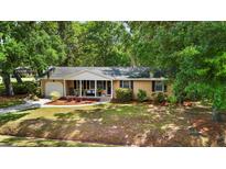 Charming single-story brick home featuring a covered porch and a well-maintained front yard with mature trees at 520 Yale Dr, Charleston, SC 29412