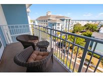 Relaxing balcony with wicker chairs and a view of the neighborhood and ocean at 5802 Palmetto Dr # B-521/519, Isle of Palms, SC 29451
