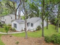 Charming single story home with white facade, mature trees, and a welcoming front porch at 987 Harbor Oaks Dr, Charleston, SC 29412