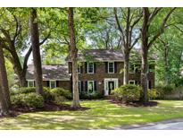 Traditional brick home with black shutters and mature trees in a lush green front yard at 108 Old Dominion Dr, North Charleston, SC 29418