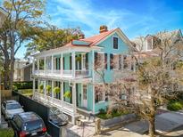 Charming two-story home with a light blue exterior, double porches, and well-maintained landscaping at 11 Franklin St, Charleston, SC 29401