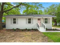 Charming brick home with white trim, a pink door, and a neatly landscaped front yard at 1109 Hillside Dr, Charleston, SC 29407