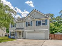 Charming two-story home featuring gray siding, blue shutters, an attached garage and a well-maintained lawn at 122 Balsam Cir, Summerville, SC 29485