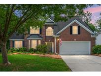 Charming two-story brick home with a well-manicured lawn, a two-car garage, and mature trees at 1485 Endicot Way, Mount Pleasant, SC 29466