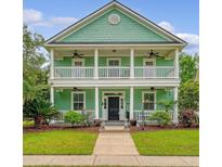 Inviting two-story home with double porches, lush landscaping, and a beautifully manicured lawn at 209 Forsythia Ave, Summerville, SC 29483