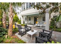 Beautiful outdoor patio with stylish furniture, a relaxing lounge chair, and a covered seating area for entertaining at 21 1/2 Pitt St, Charleston, SC 29401