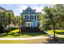 Charming blue two-story home featuring black shutters, lush landscaping, and a well-manicured lawn at 2627 Rutherford Way, Charleston, SC 29414