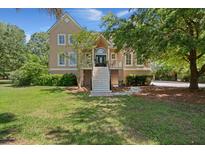 Inviting two-story home features a classic design, front staircase, and lush green lawn at 3756 Colonel Vanderhorst Circle, Mount Pleasant, SC 29466