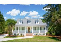 Charming single-Gathering home featuring a welcoming front porch, complemented by lush landscaping and a well-manicured lawn at 380 Tidal Reef Cir, Mount Pleasant, SC 29464
