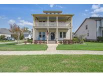 Charming two-story home featuring a double front porch and landscaped front yard at 4303 Misty Hollow Ln, Ravenel, SC 29470