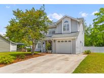 Charming two-story home with a well-manicured lawn and a one-car garage at 828 Williamsburg Ln, Charleston, SC 29414