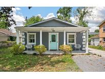 Charming gray home featuring a welcoming porch, aqua front door, and well-maintained landscaping at 928 Sycamore Ave, Charleston, SC 29407