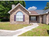 Charming brick home with a well-manicured lawn and inviting walkway leading to the front door at 9630 N Cardinal Dr, Ladson, SC 29456