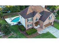 Stunning aerial view of a brick two-story home with a sparkling pool and manicured landscaping at 102 Six Point Ct, Goose Creek, SC 29445