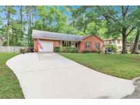 Charming brick home featuring a spacious driveway, attached garage, and well-maintained front yard at 109 Williams Ct, Goose Creek, SC 29445