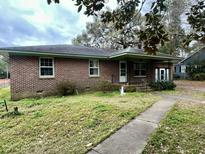 Charming single-story brick home with a covered porch and mature trees at 113 Germantown Rd, Summerville, SC 29483