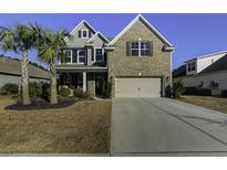 Attractive two-story home with brick and siding, palm trees, and a well-manicured lawn at 1209 Hammrick Ln, Johns Island, SC 29455