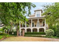 Charming two-story home with a landscaped front yard and a double porch with white pillars at 121 W Shipyard Rd, Mount Pleasant, SC 29464