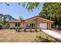 Charming single-story home featuring a brick accent, manicured lawn, and an attached one-car garage at 133 Tall Spruce Rd, Moncks Corner, SC 29461