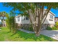 Charming home with stone accents and a well-maintained lawn, enhanced by mature trees and clear blue skies at 1616 Refuge Run, Charleston, SC 29412
