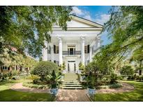 Stately white home with a grand entrance and lush landscaping, creating a picturesque curb appeal at 172 Tradd St, Charleston, SC 29401