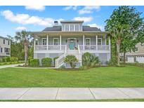Inviting two-story home featuring a spacious front porch, well-manicured lawn, and lush tropical landscaping at 1776 W Canning Dr, Mount Pleasant, SC 29466
