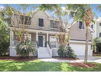 Inviting two-story home featuring a charming front porch, well-manicured lawn, and attached garage at 1985 Shields Ln, Mount Pleasant, SC 29466