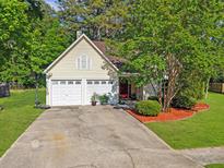 Charming one-story home with a two-car garage, mature trees, and a well-manicured lawn at 206 Challis Ct, Goose Creek, SC 29445
