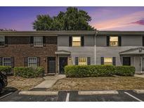 Charming exterior of townhomes with brick and gray siding, manicured shrubs, and convenient parking spaces at 21 Rivers Point Row # 3C, Charleston, SC 29412