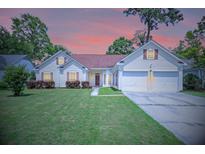 Charming single Gathering home with a well-manicured lawn and two-car garage nestled among mature trees at 217 Smithfield Ave, Summerville, SC 29485