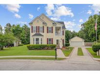 Charming two-story home with a detached garage, red shutters, and a manicured front yard at 249 Old Savannah Dr, Goose Creek, SC 29445