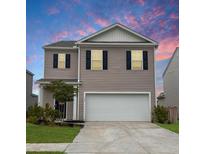 Charming two-story home with a two car garage, beautiful siding, and a well manicured lawn at 323 Bear Paw Ln, Summerville, SC 29486