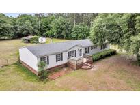 Charming single-story home with white siding, black shutters, and a cozy front deck at 5056 Red Oak Rd, Cottageville, SC 29435