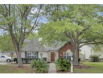 Charming single-story home featuring a well-manicured lawn, mature trees, and inviting curb appeal at 8774 Adaline St, North Charleston, SC 29406