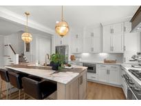 Bright, updated kitchen with a marble island, stainless appliances, and modern hanging lights at 9822 Haven Loop, Johns Island, SC 29455