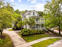Stunning two-story home featuring double porches, lush landscaping and a private driveway at 11 Dalton St, Daniel Island, SC 29492