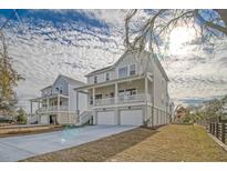 Charming coastal home featuring a two-story design, double garage, and inviting front porch with decorative columns at 1340 Lucinda St, Mount Pleasant, SC 29466